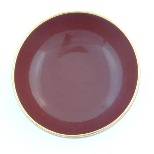 37 - A Japanese bowl with a red glaze and gilt rim. Character marks under. Approx. 4