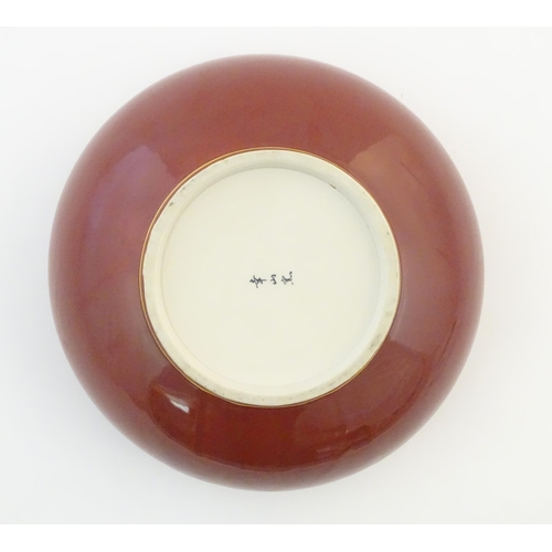 37 - A Japanese bowl with a red glaze and gilt rim. Character marks under. Approx. 4