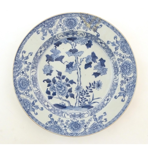 46 - A Chinese blue and white plate decorated with flowers and foliage. With stylised motifs to reverse. ... 