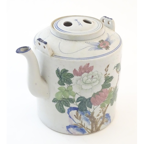 60A - A large Oriental teapot decorated with flowers, foliage and a bird, with scrolling brushwork detail.... 