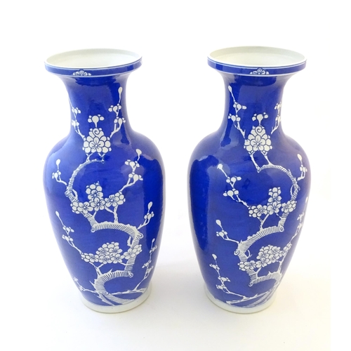 62 - A pair of Oriental vases with a blue glaze decorated with prunus flowers in blossom. Character marke... 