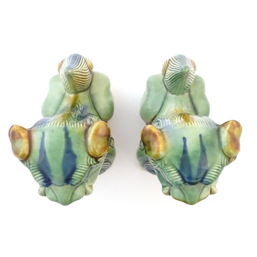 67 - A matched pair of Chinese models of foo dogs / guardian lions with a green, blue and ochre glaze. Ap... 