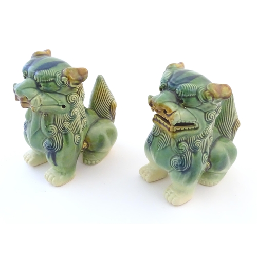 67 - A matched pair of Chinese models of foo dogs / guardian lions with a green, blue and ochre glaze. Ap... 