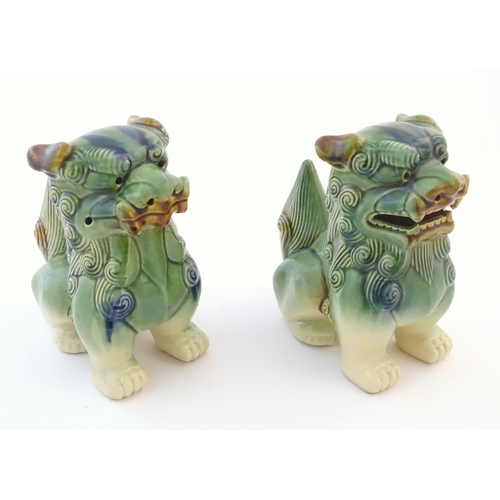 67 - A matched pair of Chinese models of foo dogs / guardian lions with a green, blue and ochre glaze. Ap... 