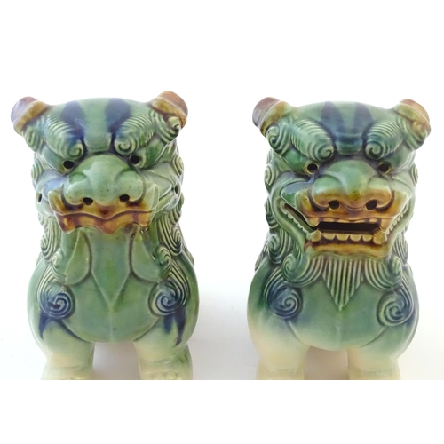 67 - A matched pair of Chinese models of foo dogs / guardian lions with a green, blue and ochre glaze. Ap... 