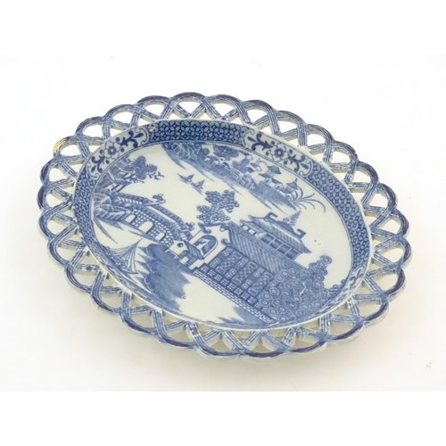 72 - A blue and white dish of oval form with reticulated border decorated with a seascape scene with pago... 