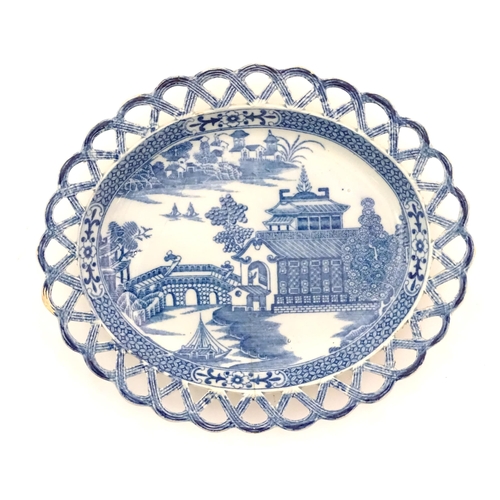 72 - A blue and white dish of oval form with reticulated border decorated with a seascape scene with pago... 