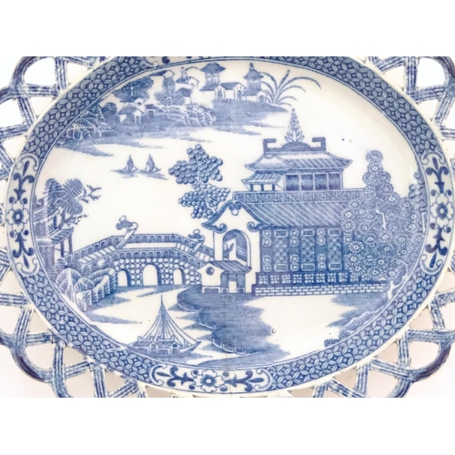 72 - A blue and white dish of oval form with reticulated border decorated with a seascape scene with pago... 