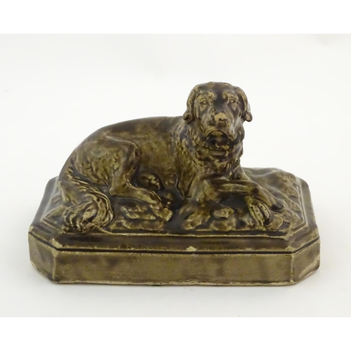 76 - A salt glazed pottery model of a dog on a rectangular plinth. Approx. 5 3/4