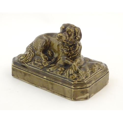 76 - A salt glazed pottery model of a dog on a rectangular plinth. Approx. 5 3/4