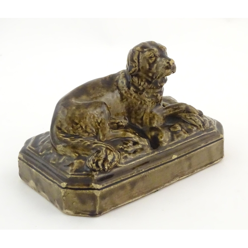 76 - A salt glazed pottery model of a dog on a rectangular plinth. Approx. 5 3/4