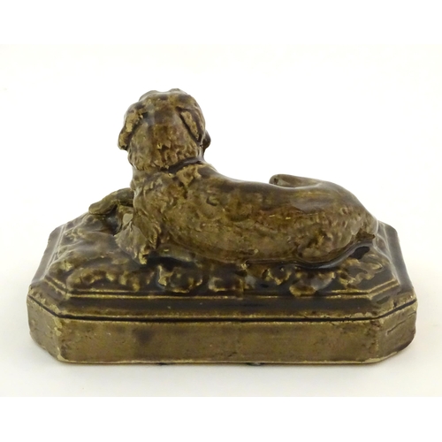 76 - A salt glazed pottery model of a dog on a rectangular plinth. Approx. 5 3/4