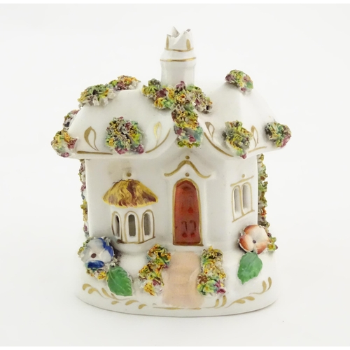 79 - A Staffordshire pottery pastille burner modelled as a cottage, decorated with encrusted flowers. App... 