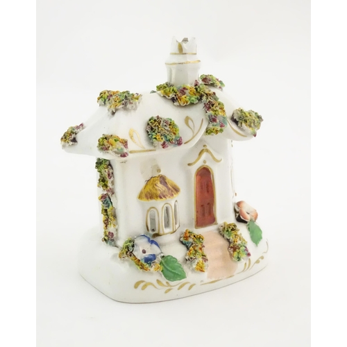 79 - A Staffordshire pottery pastille burner modelled as a cottage, decorated with encrusted flowers. App... 