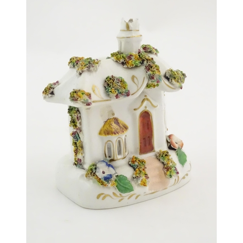 79 - A Staffordshire pottery pastille burner modelled as a cottage, decorated with encrusted flowers. App... 