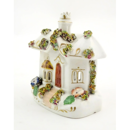 79 - A Staffordshire pottery pastille burner modelled as a cottage, decorated with encrusted flowers. App... 