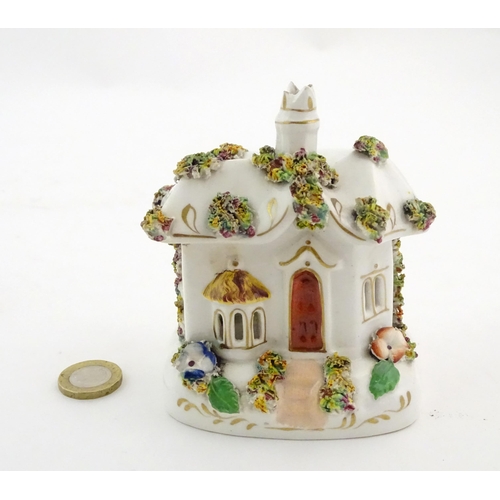 79 - A Staffordshire pottery pastille burner modelled as a cottage, decorated with encrusted flowers. App... 