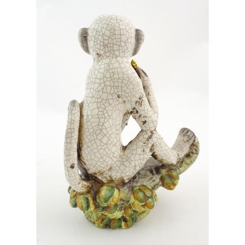 86 - An Oriental style model of a monkey with a banana seated on a branch. Approx. 10 1/2