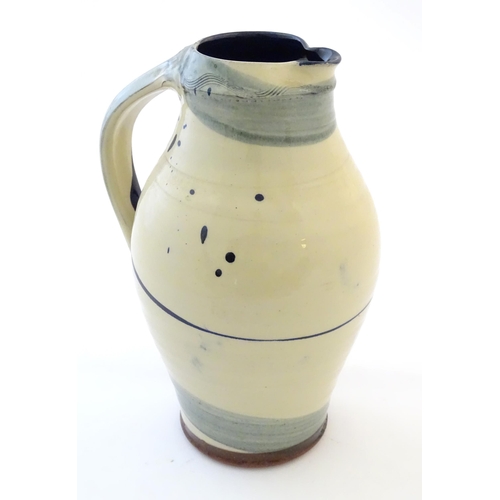 90 - A studio pottery jug with drip and brushwork decoration. Indistinctly signed under. Approx. 11 1/4