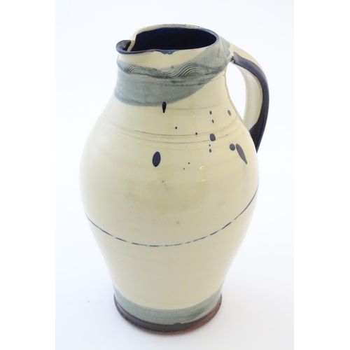 90 - A studio pottery jug with drip and brushwork decoration. Indistinctly signed under. Approx. 11 1/4