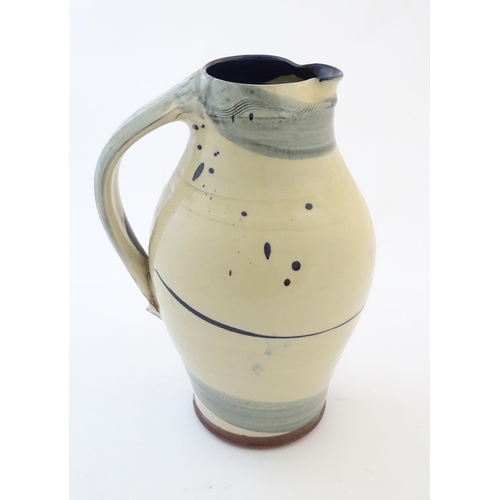 90 - A studio pottery jug with drip and brushwork decoration. Indistinctly signed under. Approx. 11 1/4