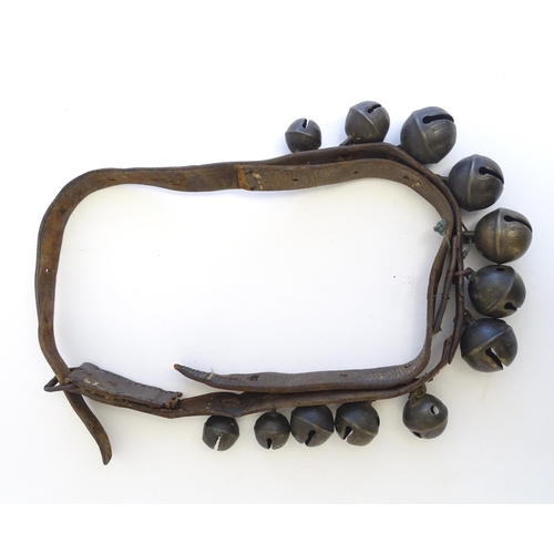 1190 - Agricultural bygones : Twelve late 19th / early 20thC crotal bells / rumble bells mounted on a leath... 