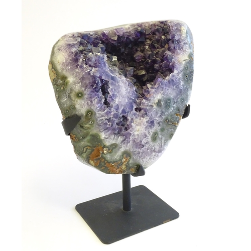 1207 - An amethyst crystal geode with polished edge. Mounted on a stand. Amethyst approx. 7 3/4