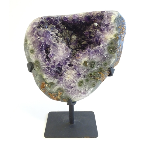 1207 - An amethyst crystal geode with polished edge. Mounted on a stand. Amethyst approx. 7 3/4