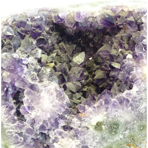 1207 - An amethyst crystal geode with polished edge. Mounted on a stand. Amethyst approx. 7 3/4