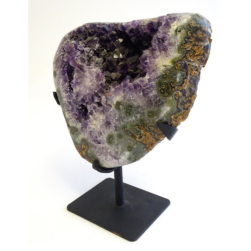 1207 - An amethyst crystal geode with polished edge. Mounted on a stand. Amethyst approx. 7 3/4