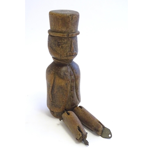 1208 - A 19thC folk art carved wooden naive model of a gentleman wearing a top hat, with articulated legs. ... 