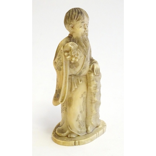 1245 - A 19thC Oriental carved ivory figure depicting a gentleman in robes. Approx. 4 1/2