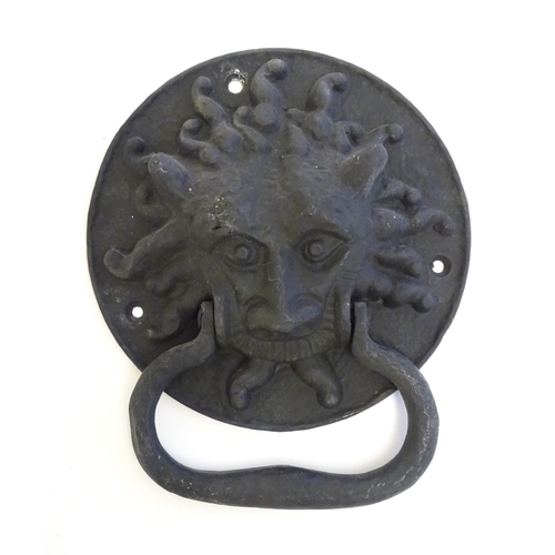 1252 - A 20thC cast door knocker with mask detail. Approx. 8 1/4