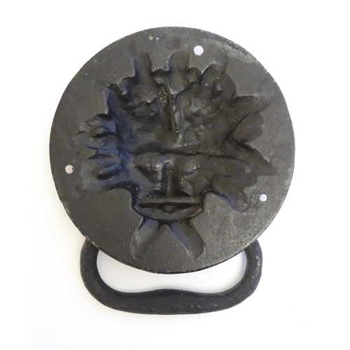 1252 - A 20thC cast door knocker with mask detail. Approx. 8 1/4