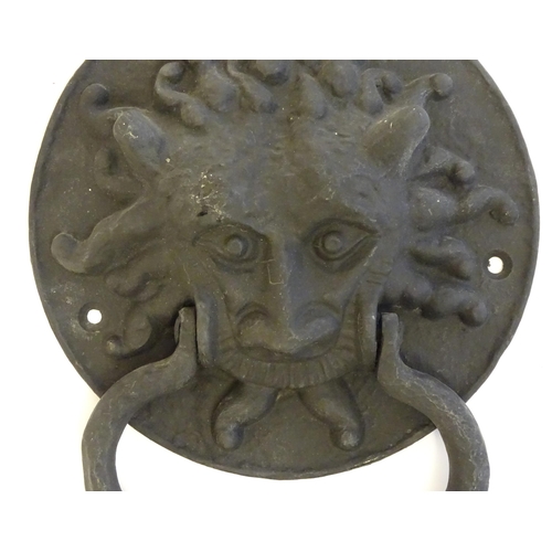 1252 - A 20thC cast door knocker with mask detail. Approx. 8 1/4