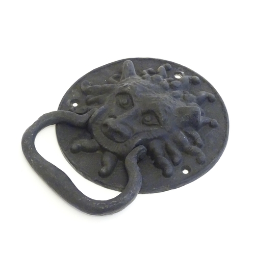 1252 - A 20thC cast door knocker with mask detail. Approx. 8 1/4