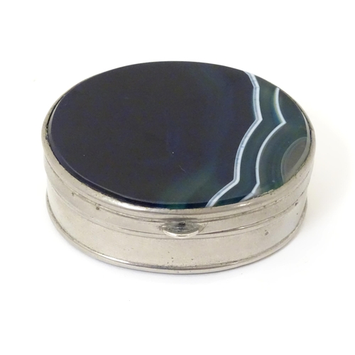 326 - A silver plate pill box of oval form set with blue banded agate to lid and base. Approx 2