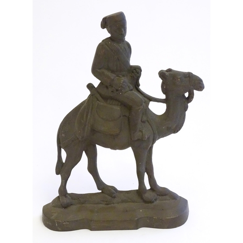 1261 - A 20thC cast door stop / door porter modelled as a man riding a camel. Approx. 11 1/4