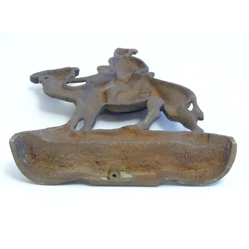 1261 - A 20thC cast door stop / door porter modelled as a man riding a camel. Approx. 11 1/4