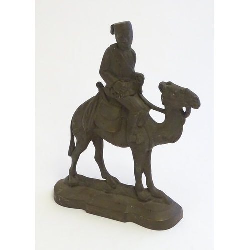 1261 - A 20thC cast door stop / door porter modelled as a man riding a camel. Approx. 11 1/4