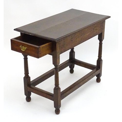 2080 - An early 20thC oak side table with a rectangular moulded top above a single long drawer and four tur... 