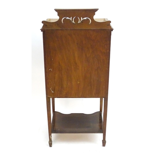 2083 - An early 20thC mahogany music cabinet with a shaped pierced upstand and five drawers with drop ends,... 