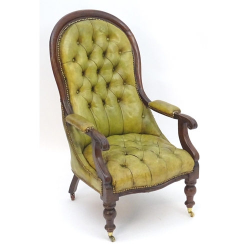 2084 - A Victorian mahogany armchair with a moulded frame and deep buttoned leather upholstery with brass s... 