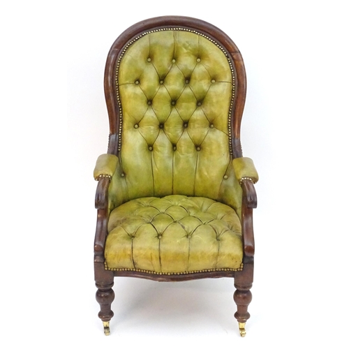 2084 - A Victorian mahogany armchair with a moulded frame and deep buttoned leather upholstery with brass s... 