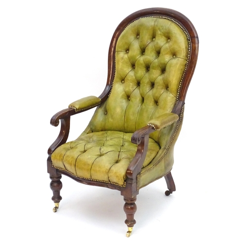 2084 - A Victorian mahogany armchair with a moulded frame and deep buttoned leather upholstery with brass s... 