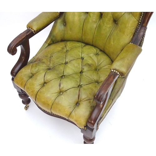 2084 - A Victorian mahogany armchair with a moulded frame and deep buttoned leather upholstery with brass s... 