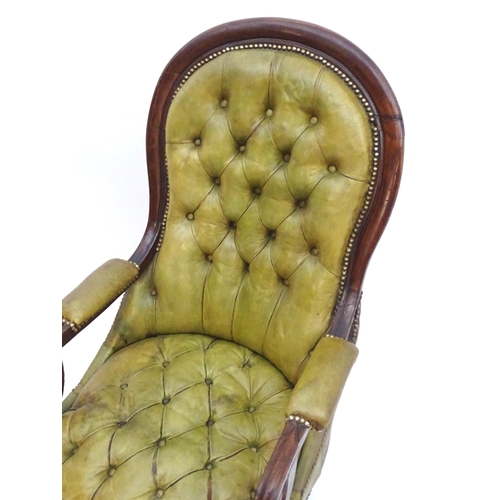 2084 - A Victorian mahogany armchair with a moulded frame and deep buttoned leather upholstery with brass s... 