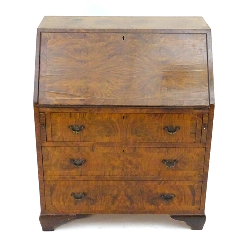 2088 - A late 19thC / early 20thC walnut bureau with a fall front above three long drawers having brass han... 