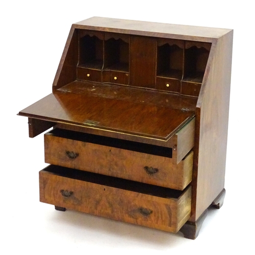 2088 - A late 19thC / early 20thC walnut bureau with a fall front above three long drawers having brass han... 