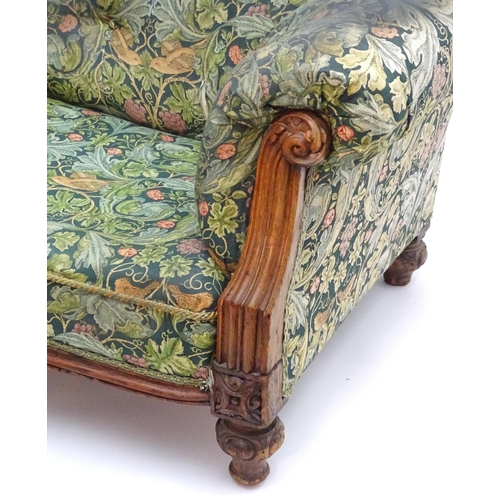 2092 - A Victorian oak framed Chesterfield settee, with scrolled and carved arms above floral detailing and... 